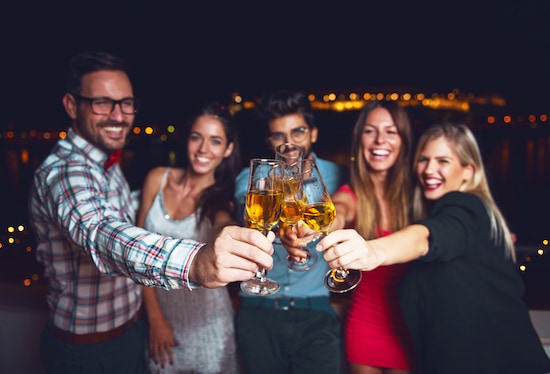 Group of people having a party on the roof, cheering with champagne